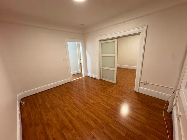 an empty room with wooden floor and closet