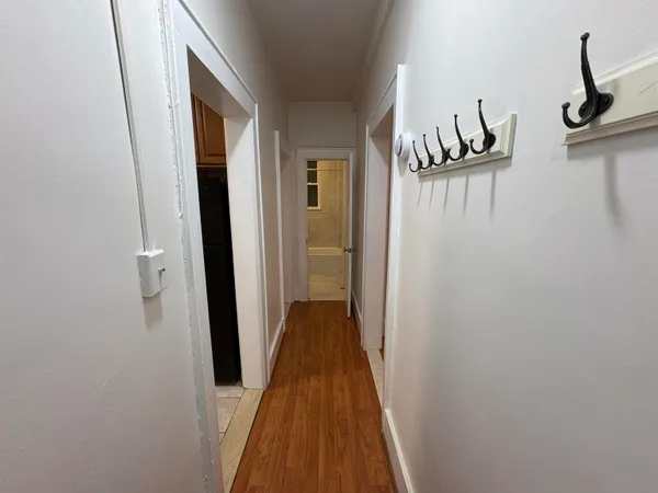 a view of a hallway with wooden floor and dining room