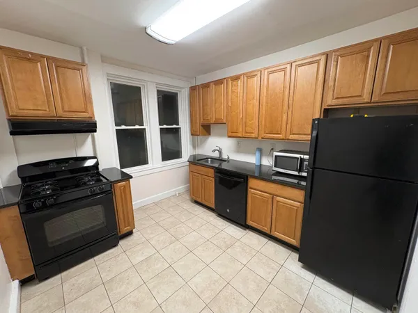 a kitchen with granite countertop a refrigerator stove top oven and sink