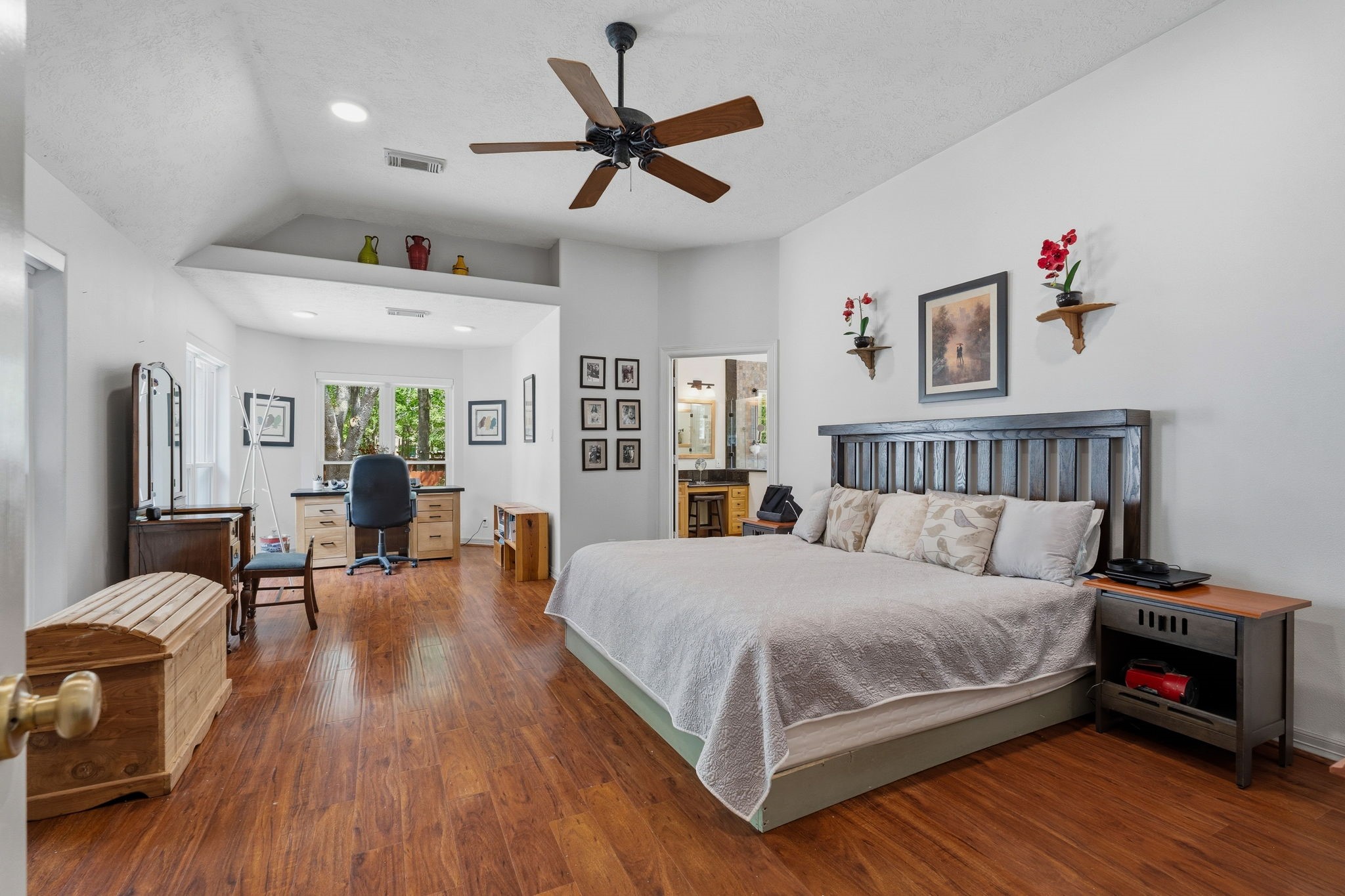11714 Creek View Lane Conroe, TX 77385 - Photo 17 of 46 a bedroom with a bed a couch and a chandelier