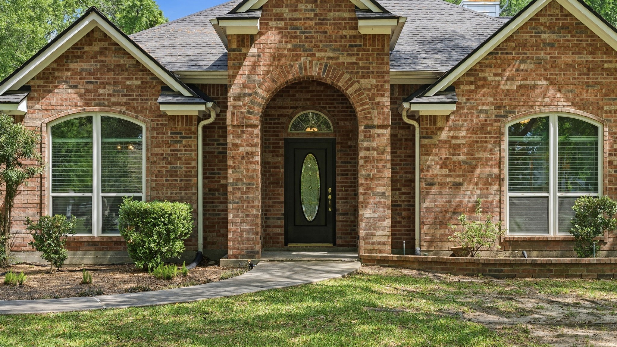 11714 Creek View Lane Conroe, TX 77385 - Photo 4 of 46 a view of a brick house with potted plants and a large window
