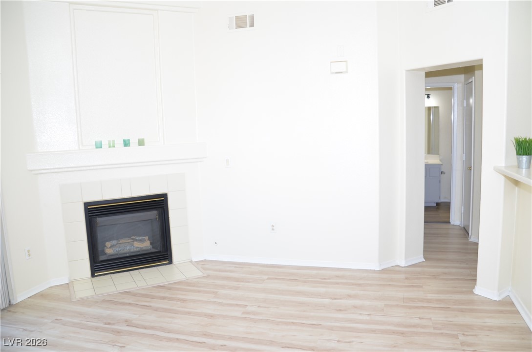 1881 West Alexander Road, Unit 2101 North Las Vegas, NV 89032 - Photo 12 of 37 Unfurnished living room featuring a tile fireplace and light wood finished floors