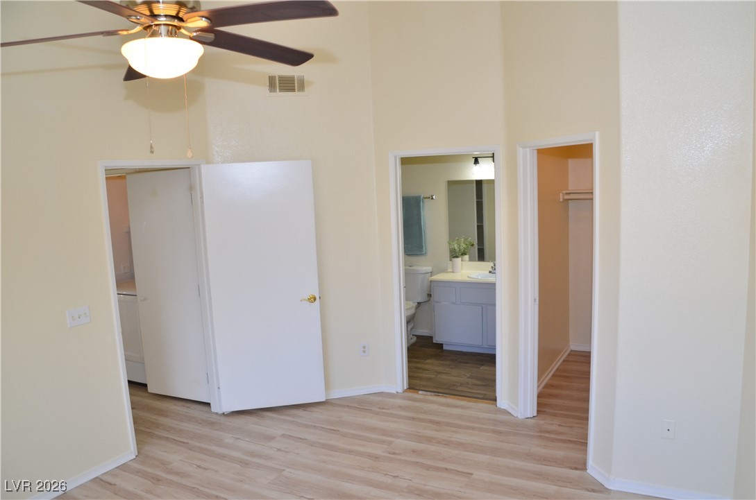 1881 West Alexander Road, Unit 2101 North Las Vegas, NV 89032 - Photo 13 of 37 Unfurnished bedroom featuring light wood-style floors, a walk in closet, a high ceiling, a ceiling fan, and ensuite bath