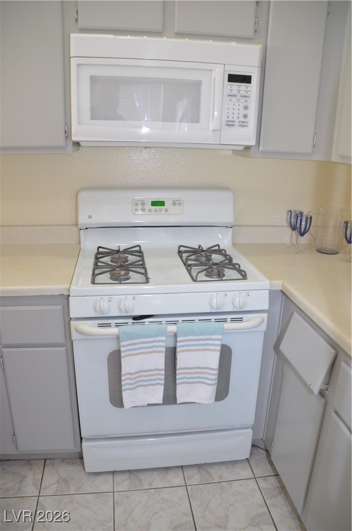 1881 West Alexander Road, Unit 2101 North Las Vegas, NV 89032 - Photo 30 of 37 Kitchen with white gas range, light countertops, and gray cabinetry