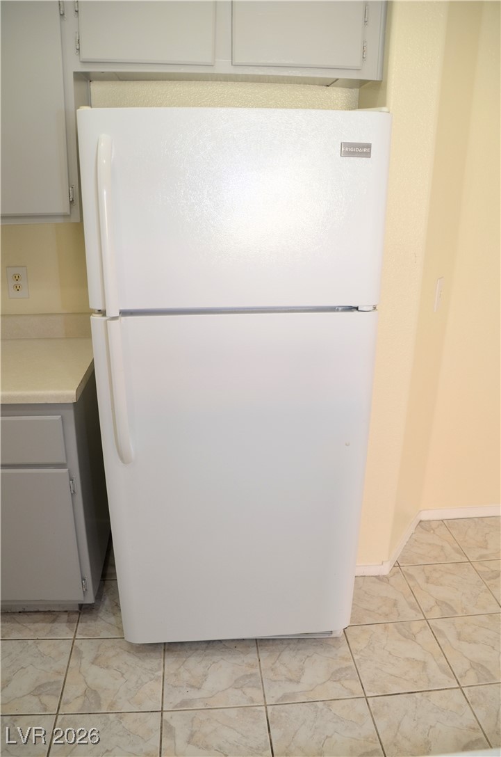 1881 West Alexander Road, Unit 2101 North Las Vegas, NV 89032 - Photo 31 of 37 Kitchen with freestanding refrigerator, light countertops, light marble finish flooring, and gray cabinets
