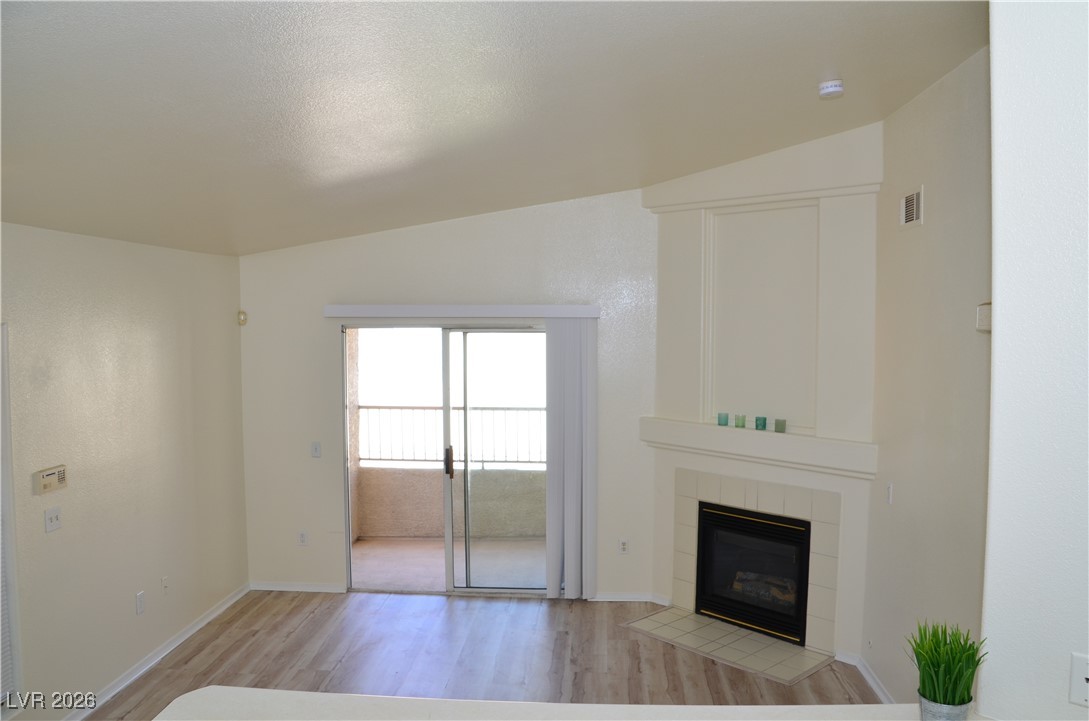 1881 West Alexander Road, Unit 2101 North Las Vegas, NV 89032 - Photo 9 of 37 Unfurnished living room with light wood-style floors and a tiled fireplace