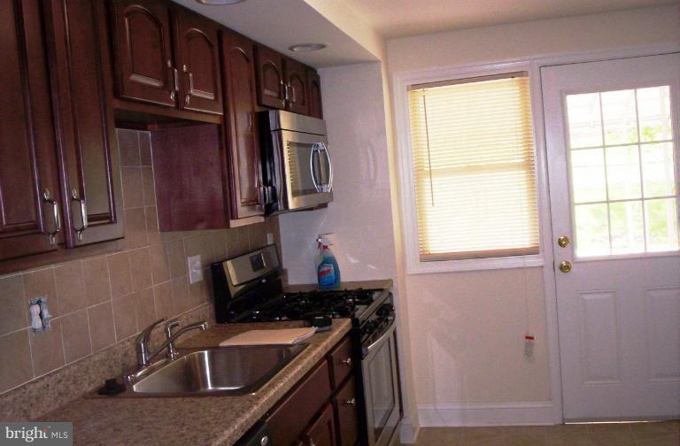 5501 Whitby Road Baltimore, MD 21206 - Photo 2 of 21 a kitchen with granite countertop a sink cabinets stainless steel appliances and a window