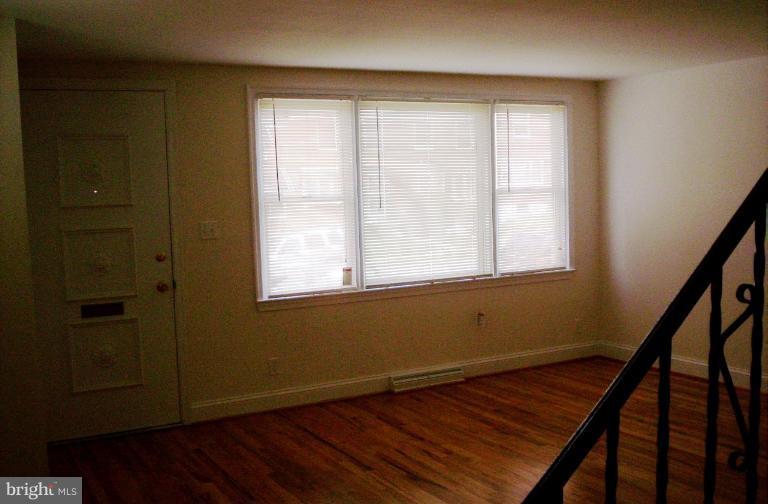 5501 Whitby Road Baltimore, MD 21206 - Photo 13 of 21 a view of an empty room with wooden floor and a window