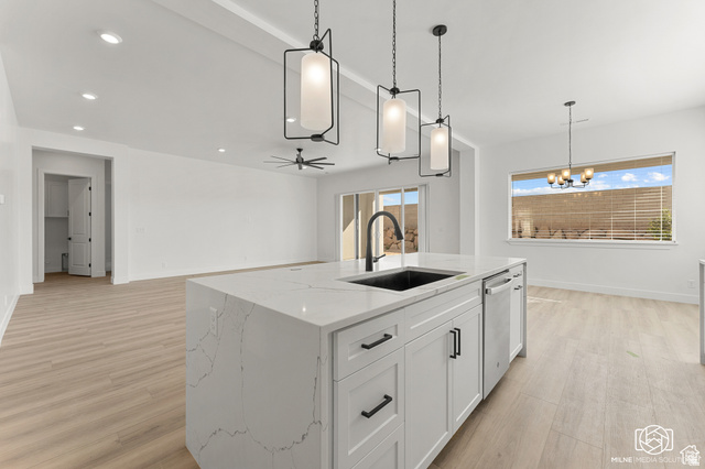 707 Spring Lily Drive St. George, UT 84790 - Photo 17 of 43 Kitchen island with a waterfall countertop, integrated sink, and pendant lighting