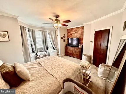 a bedroom with a bed dresser and a flat tv screen