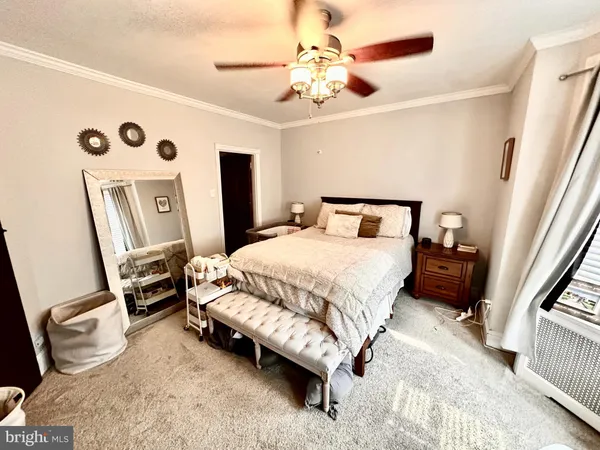 a bedroom with a bed a dresser and a chandelier