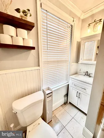 a bathroom with a toilet a sink and a window
