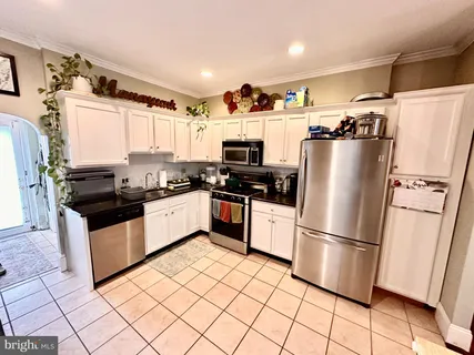 a kitchen with granite countertop a refrigerator and a stove top oven