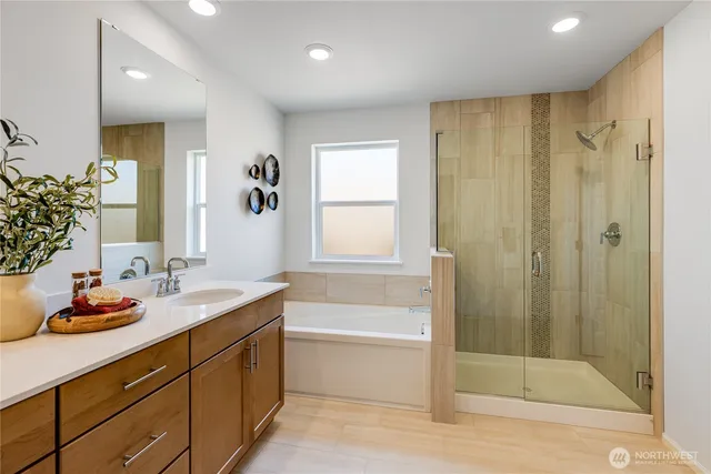 a bathroom with a granite countertop sink a mirror a bathtub and shower