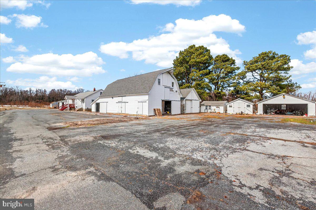 32076 Gordy Road Laurel, DE 19956 - Photo 6 of 26 a view of white house with a big yard and large trees
