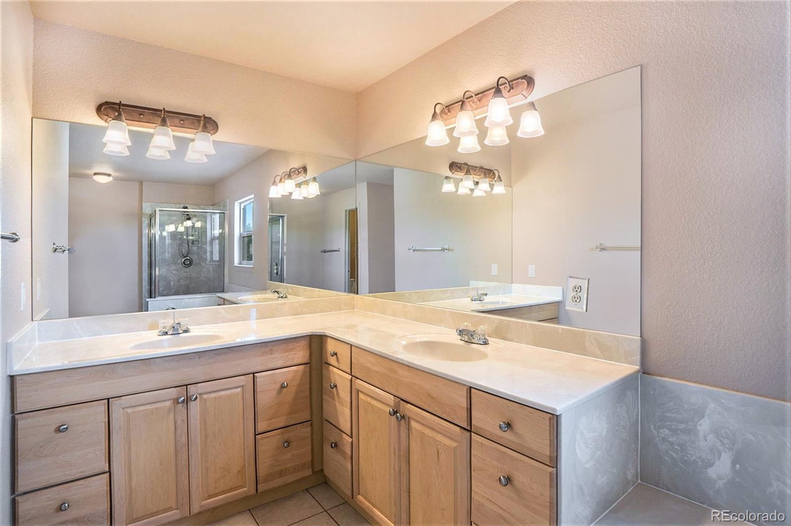 1131 Westmoreland Road Colorado Springs, CO 80907 - Photo 20 of 30 a bathroom with a sink vanity and a mirror