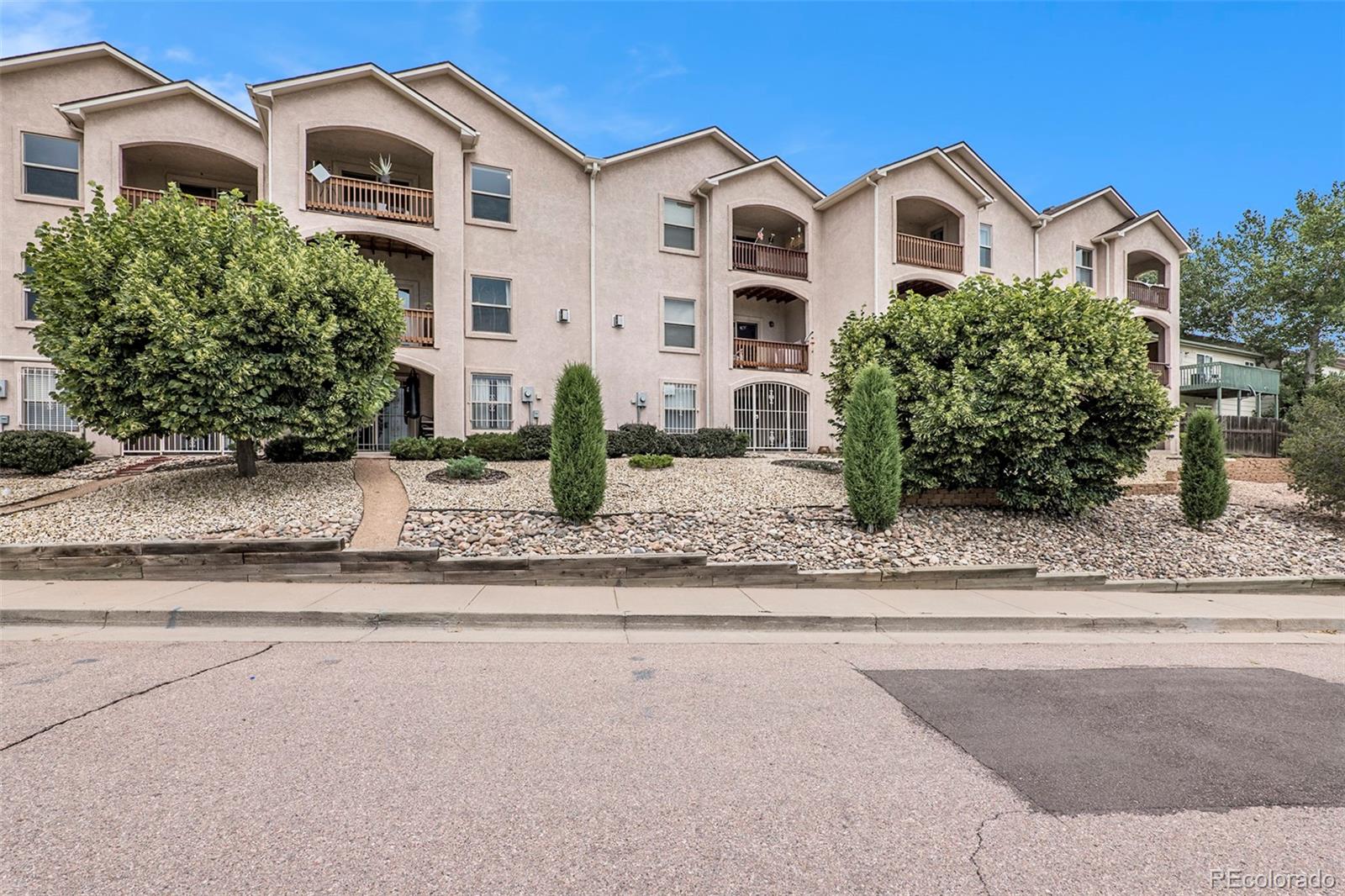 1131 Westmoreland Road Colorado Springs, CO 80907 - Photo 29 of 30 a view of white house with a yard and plants