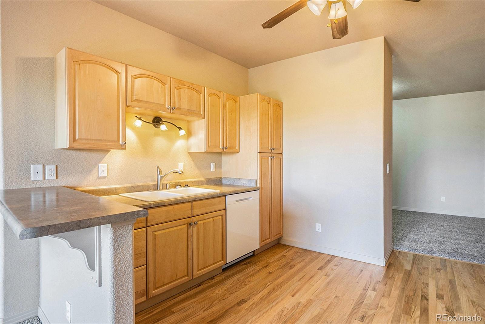 1131 Westmoreland Road Colorado Springs, CO 80907 - Photo 7 of 30 a kitchen with a sink and a refrigerator