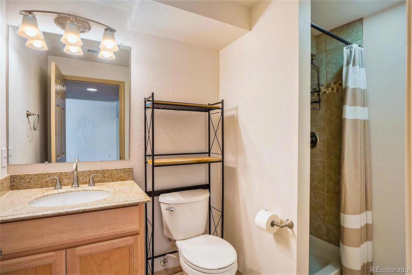 1131 Westmoreland Road Colorado Springs, CO 80907 - Photo 10 of 30 a bathroom with a granite countertop sink toilet and shower