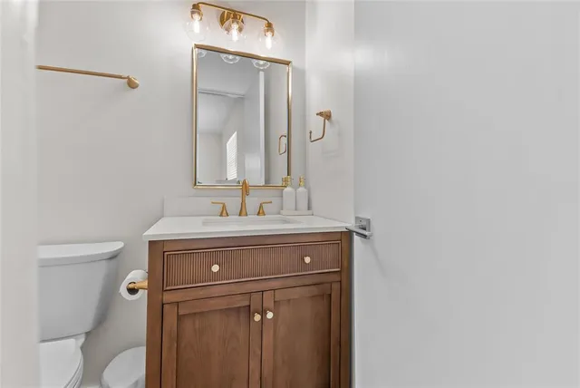 a bathroom with a sink a toilet and mirror