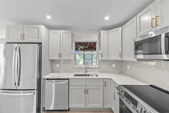 a kitchen with a sink cabinets and stainless steel appliances