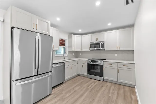 a kitchen with granite countertop stainless steel appliances and wooden cabinets