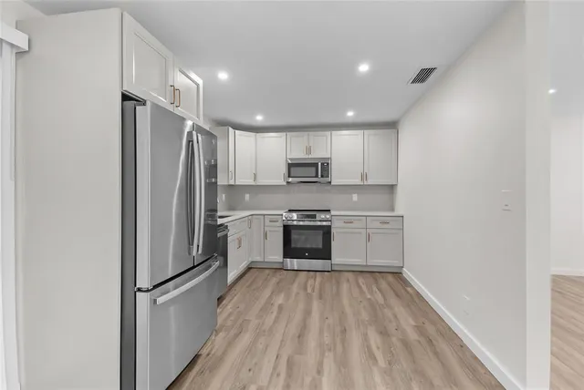 a kitchen with a refrigerator a sink and a stove top oven