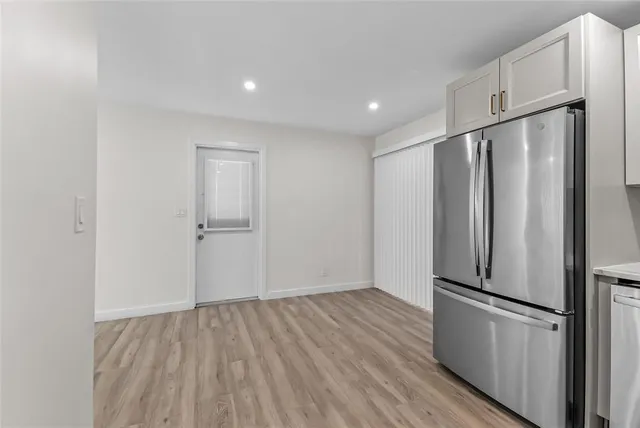 a view of a refrigerator in kitchen and wooden floor