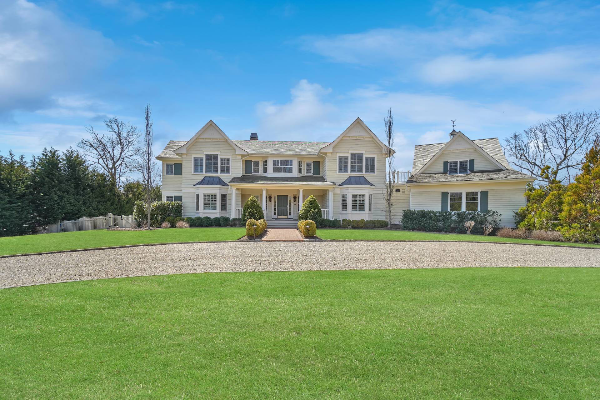 28 Bay Road Quogue, NY 11959 - Photo 6 of 35 a front view of a house with a big yard and large trees