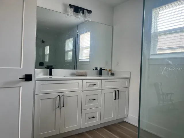 a bathroom with a double vanity sink and a mirror