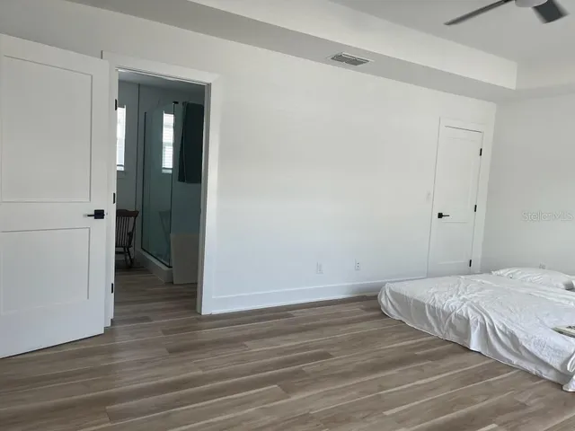 a bedroom with a bed and wooden floor