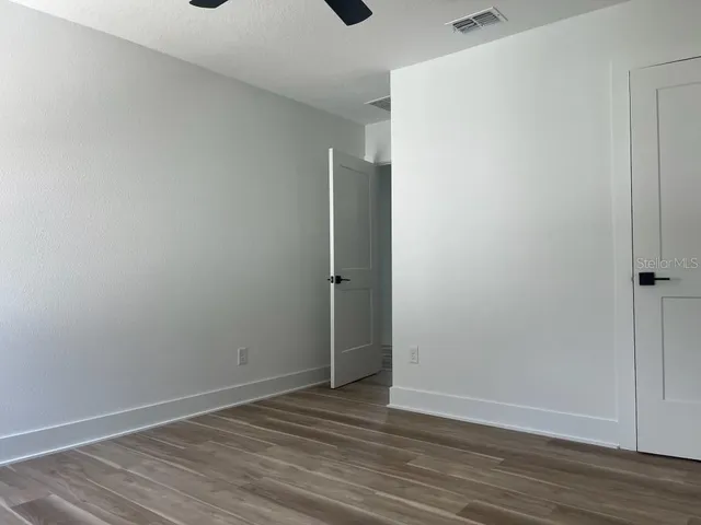 a view of an empty room with wooden floor