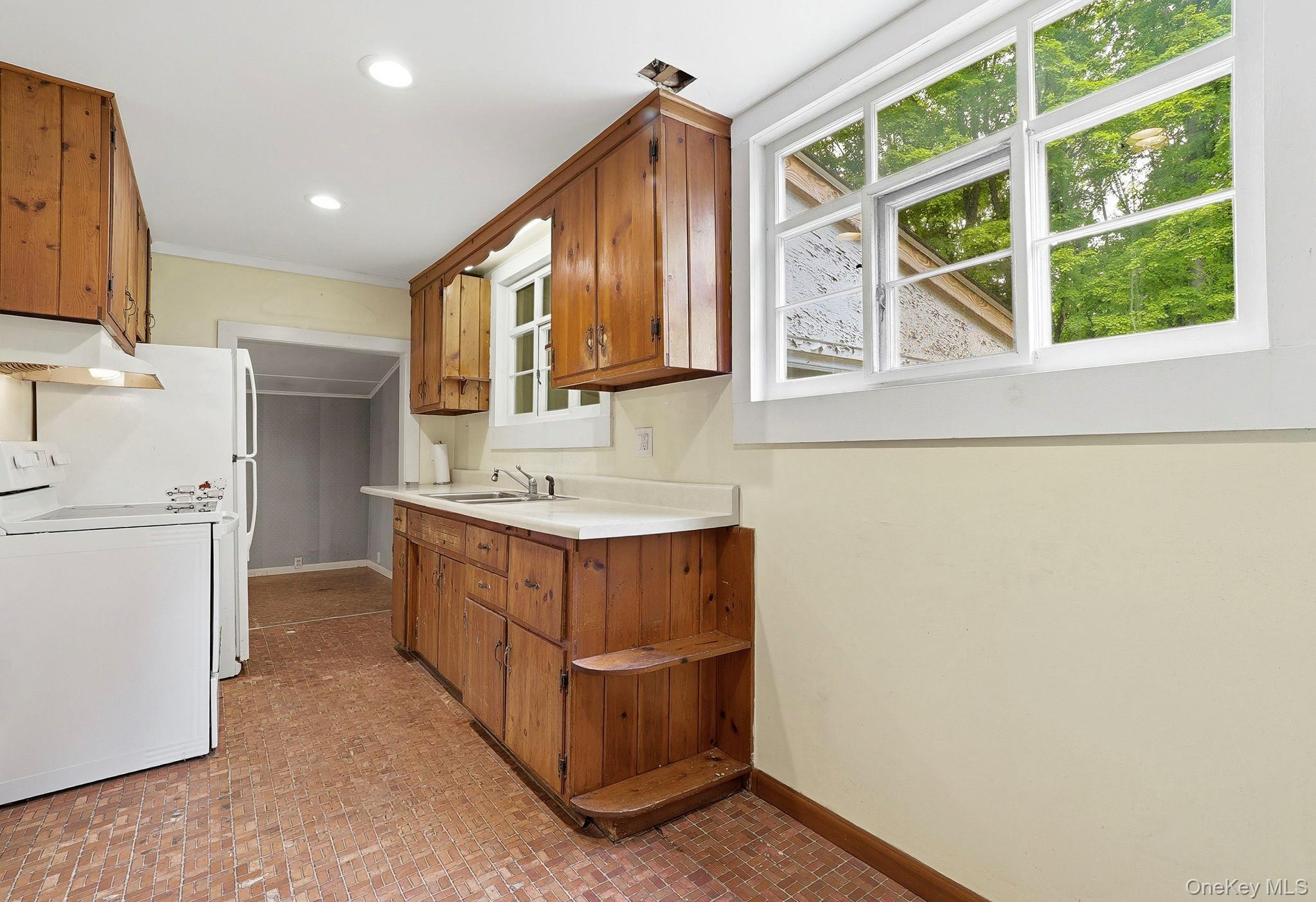 16 Hornbeck Road Poughkeepsie, NY 12603 - Photo 2 of 10 Kitchen featuring wood cabinetry, white countertops, a large window, recessed lighting, and resilient flooring