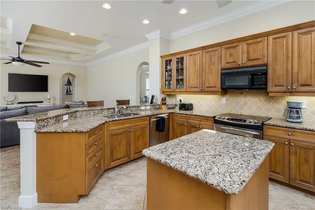 a kitchen with stainless steel appliances granite countertop a stove refrigerator sink and microwave