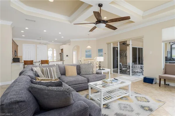 a living room with furniture kitchen view and a large window