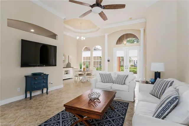 a living room with furniture a flat screen tv and a large window