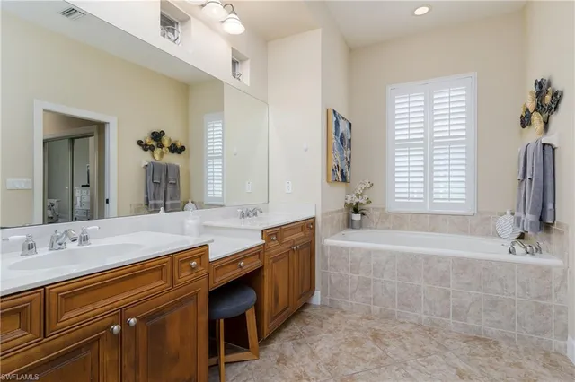 a spacious bathroom with a tub sink and mirror
