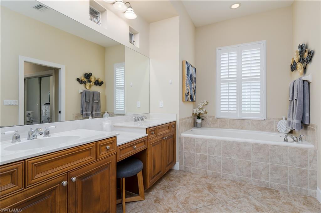8754 Hideaway Harbor Court Naples, FL 34120 - Photo 25 of 49 a spacious bathroom with a tub sink and mirror
