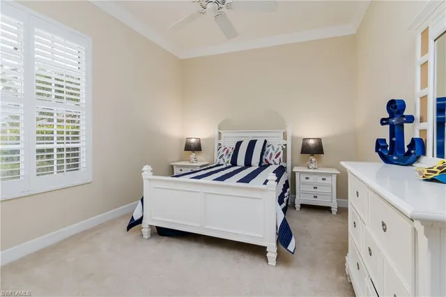 a white bed sitting in a bedroom next to a window