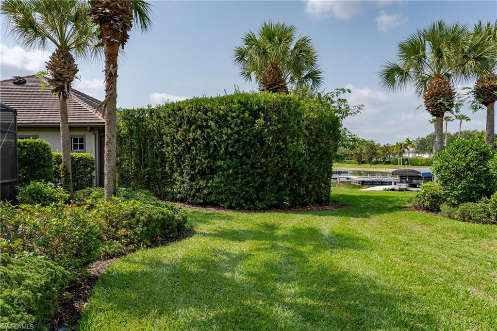 8754 Hideaway Harbor Court Naples, FL 34120 - Photo 4 of 49 a view of a garden with a building in the background