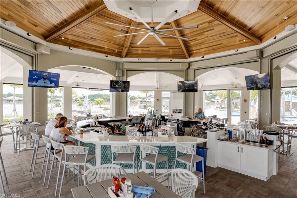 8754 Hideaway Harbor Court Naples, FL 34120 - Photo 42 of 49 a room with lots of tables a large window and chairs
