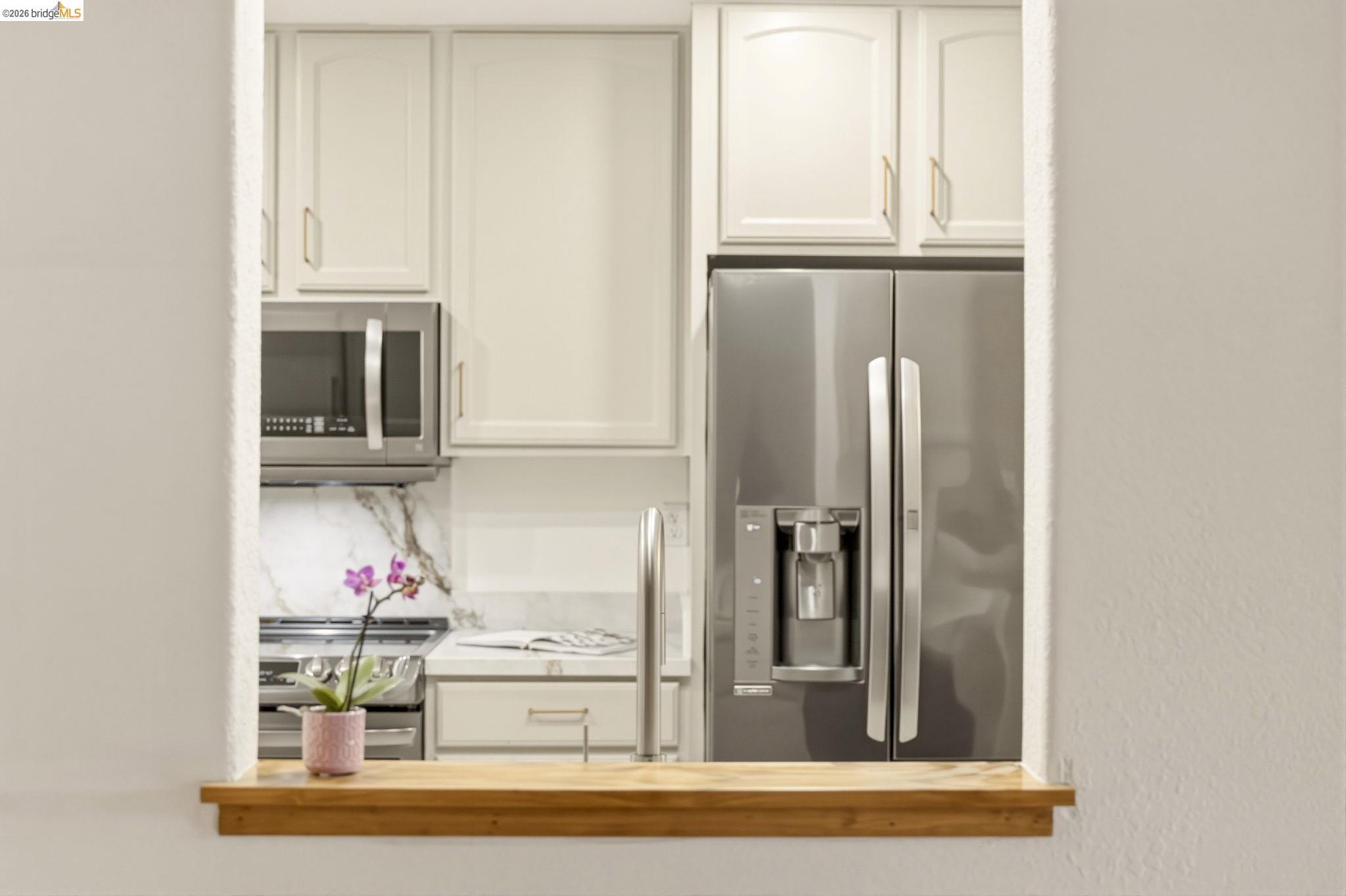 20111 West Ridge Court, Unit 13 Castro Valley, CA 94546 - Photo 13 of 50 Kitchen featuring stainless steel appliances, white cabinetry, light countertops, and backsplash
