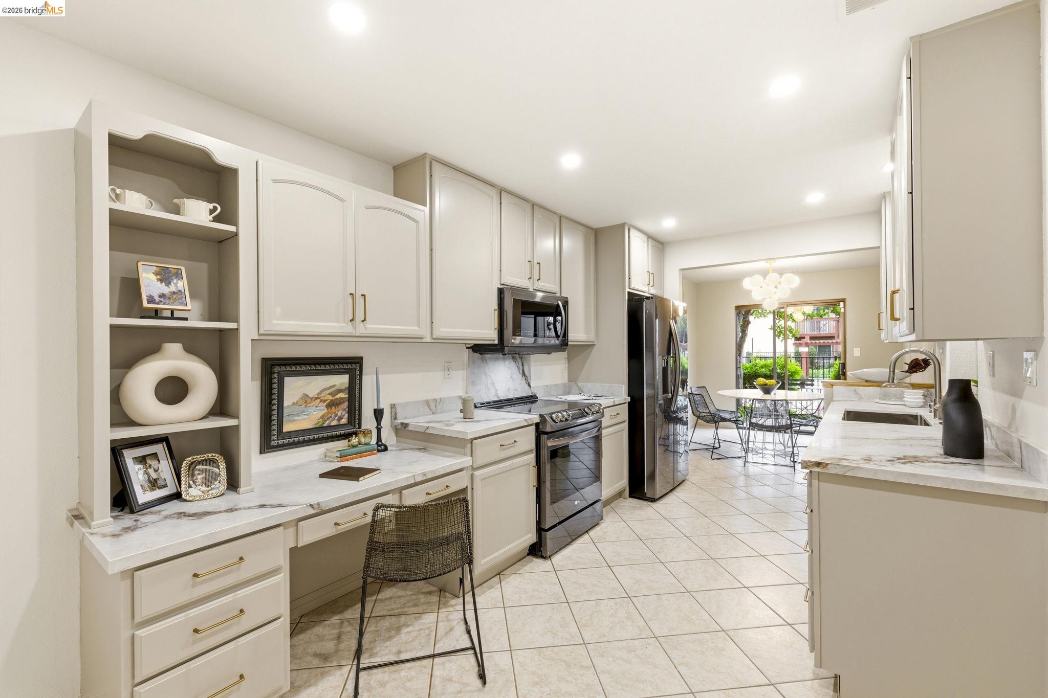 20111 West Ridge Court, Unit 13 Castro Valley, CA 94546 - Photo 10 of 50 Kitchen featuring stainless steel appliances, open shelves, light stone countertops, built in desk, and a chandelier