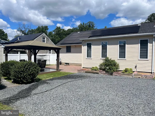 a front view of a house with a yard and potted plants