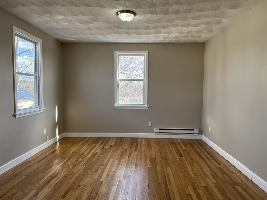 630 Metropolitan Avenue, Unit 3 Boston, MA 02136 - Photo 1 of 31 an empty room with wooden floor and windows