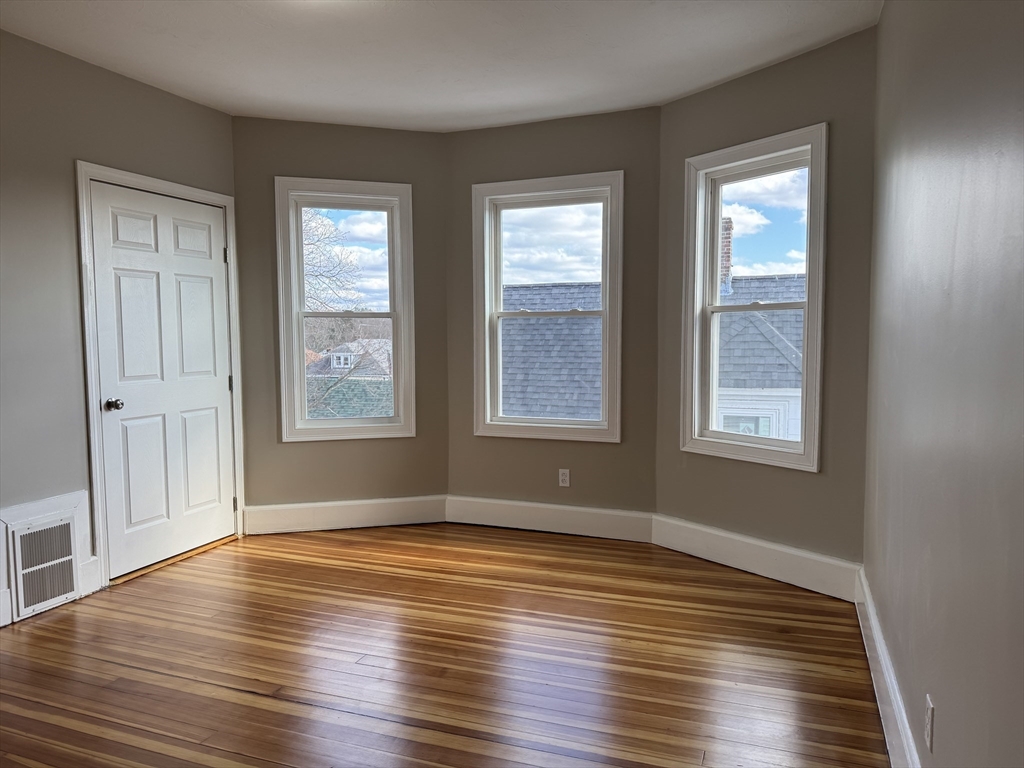 630 Metropolitan Avenue, Unit 3 Boston, MA 02136 - Photo 15 of 31 a view of an empty room with wooden floor and a window