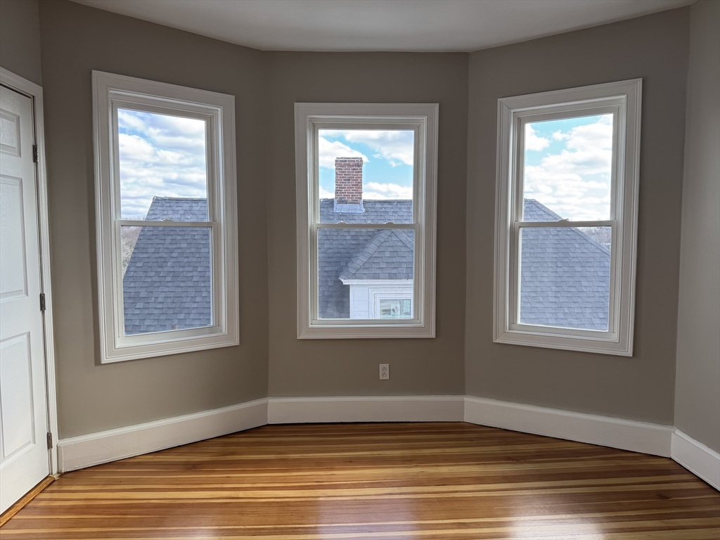 630 Metropolitan Avenue, Unit 3 Boston, MA 02136 - Photo 18 of 31 a view of an empty room with wooden floor and a window