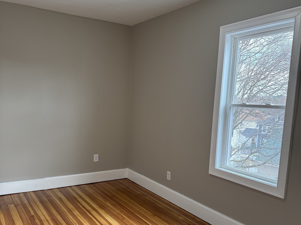 630 Metropolitan Avenue, Unit 3 Boston, MA 02136 - Photo 21 of 31 a view of an empty room with wooden floor and a window