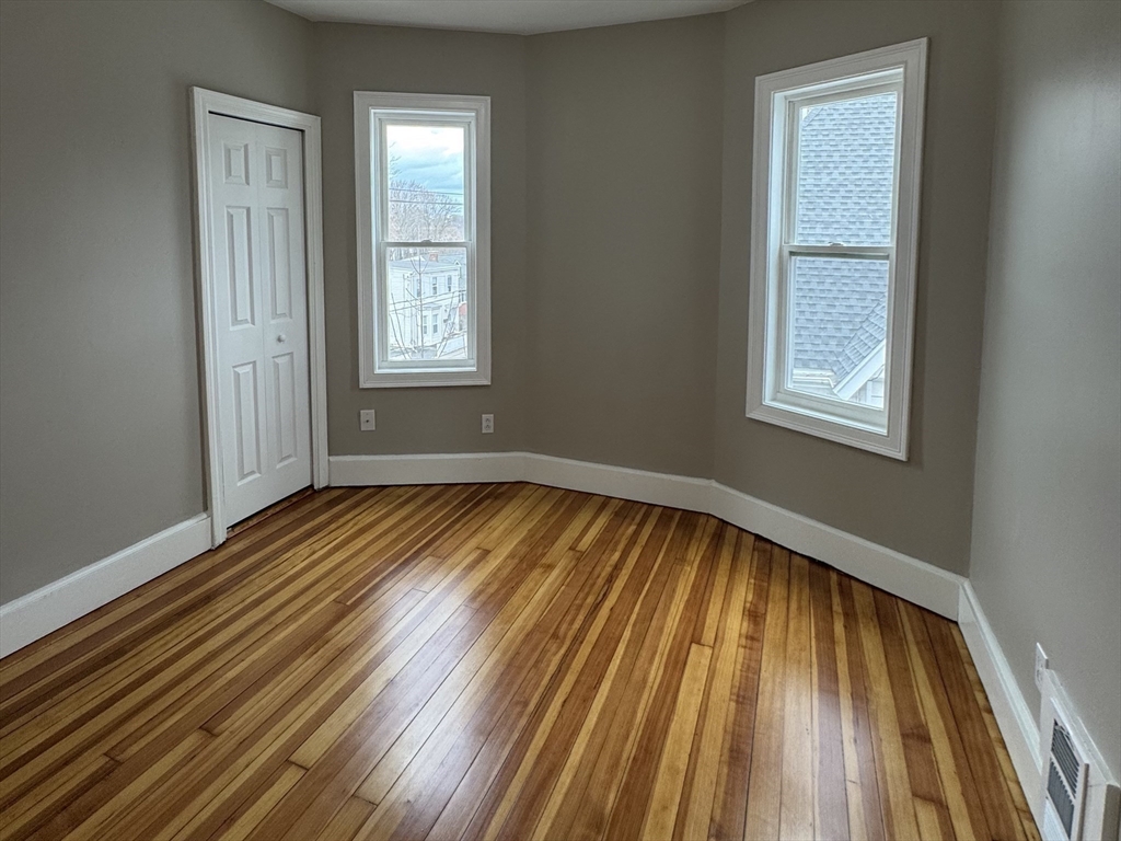 630 Metropolitan Avenue, Unit 3 Boston, MA 02136 - Photo 22 of 31 a view of an empty room with wooden floor and a window