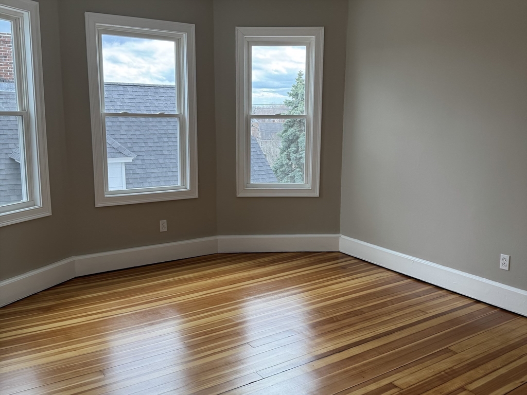 630 Metropolitan Avenue, Unit 3 Boston, MA 02136 - Photo 24 of 31 a view of an empty room with wooden floor and a window
